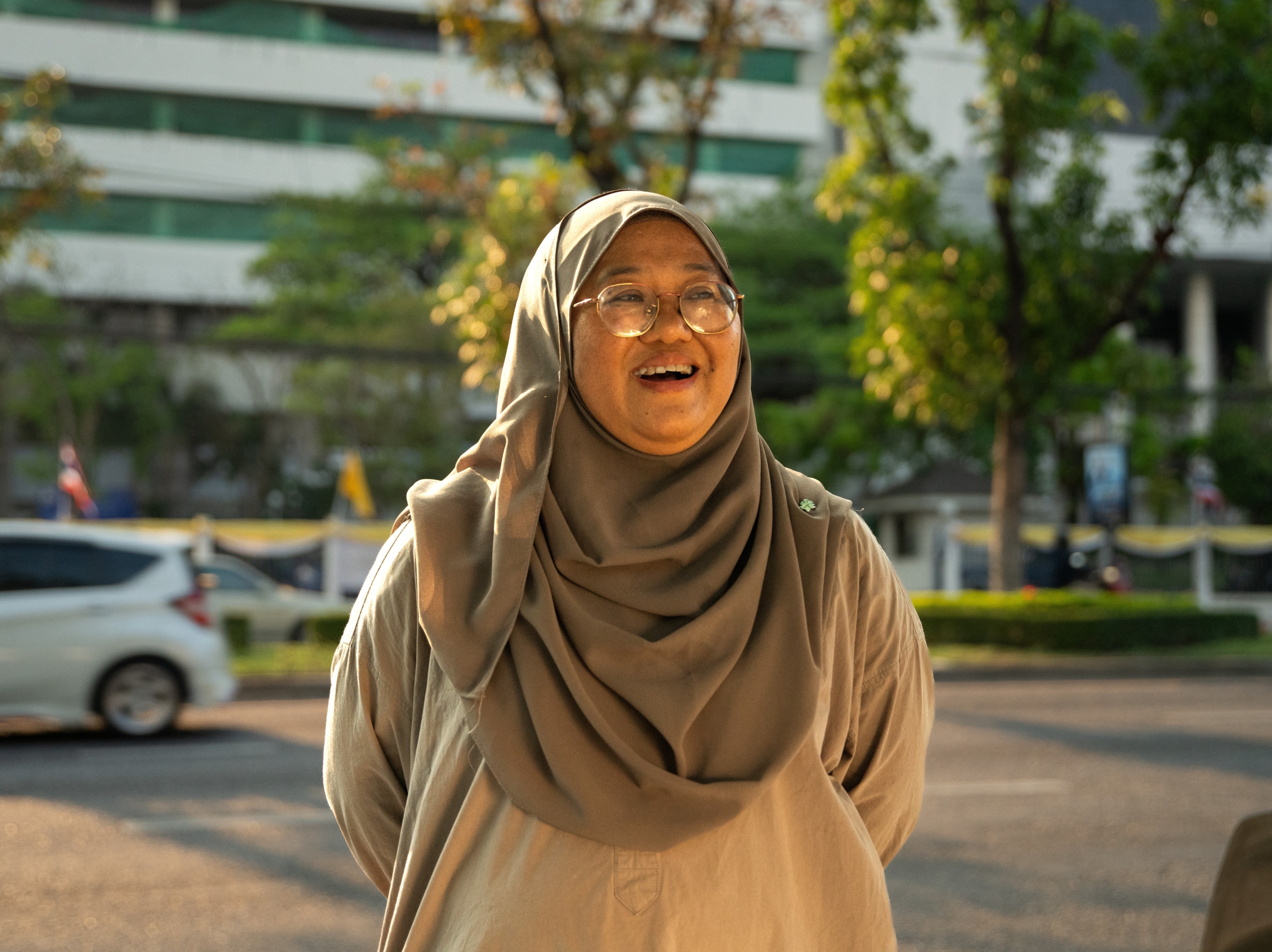 A Muslim woman human rights defender faces towards the camera and is smiling.